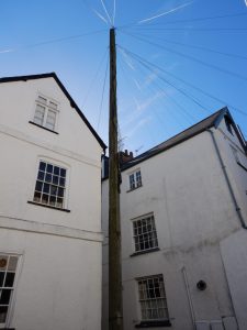A courtyard in Topsham in Devon with an enormous telegraph pole. How did it get there>