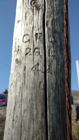 The date and GPO numbers on a dead pole still standing at Castlebay, Barra.