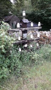 An incredibly short pole with crossarms and insulator on a roadside in Swaledale.