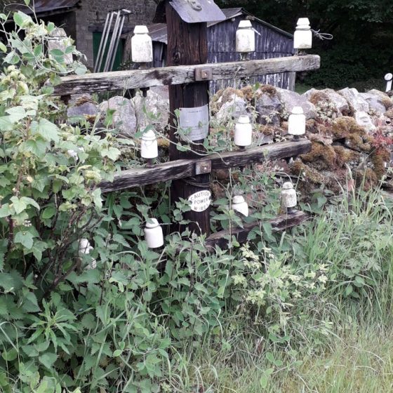 An incredibly short pole with crossarms and insulator on a roadside in Swaledale.