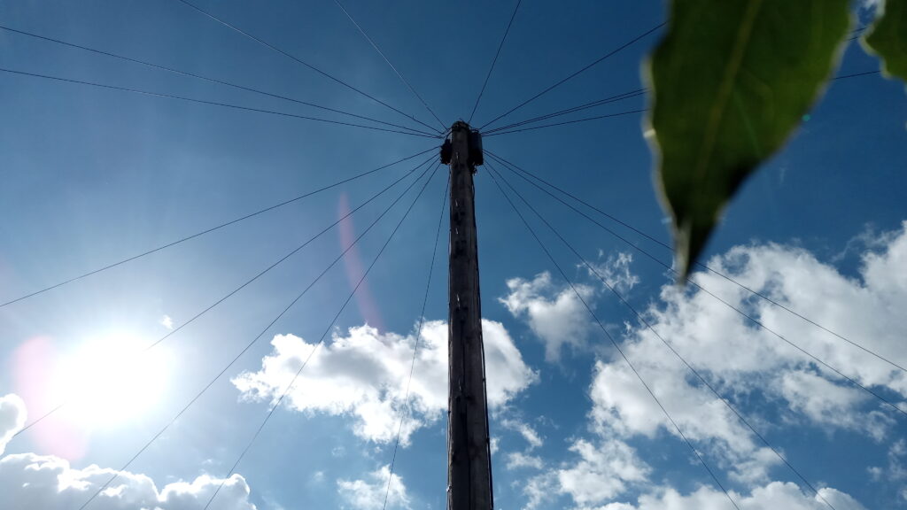 A DP with 18 visible dropwires radiating out. Sunny, light clouds blue sky background